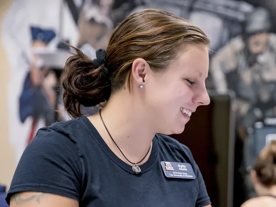 Female veteran studying in VET Center with mural in background