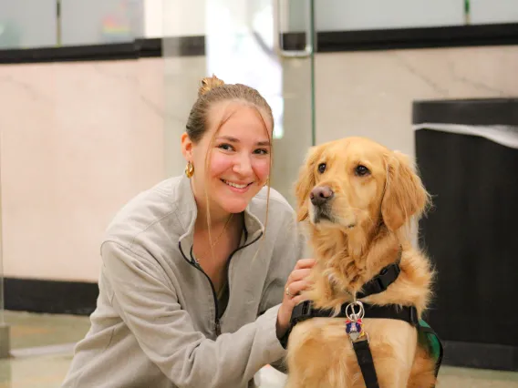 Arizona student petting Maxx the Golden Retriever