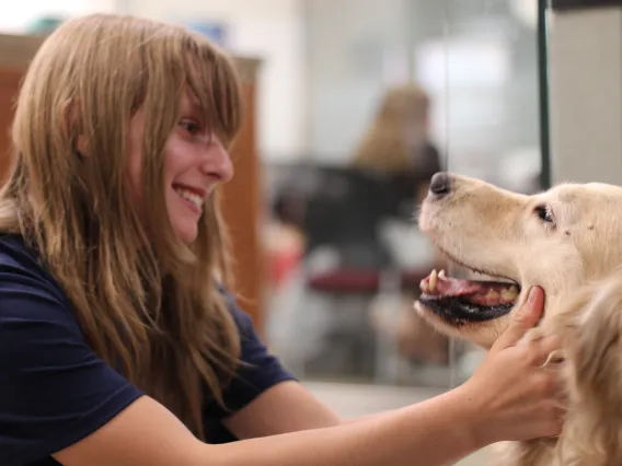 female student petting sally as she smiles