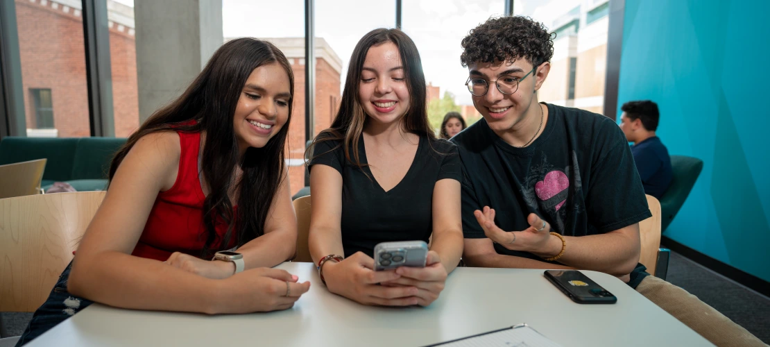 students smiling looking at a phone