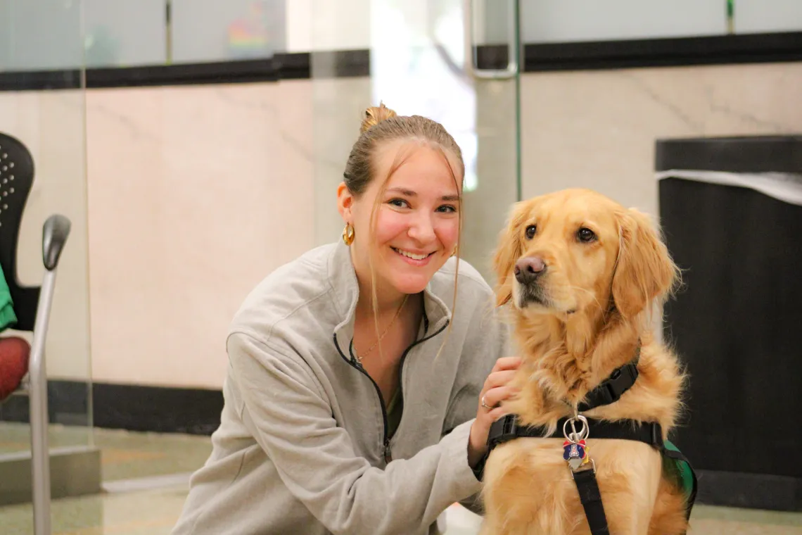 Arizona student petting Maxx the Golden Retriever