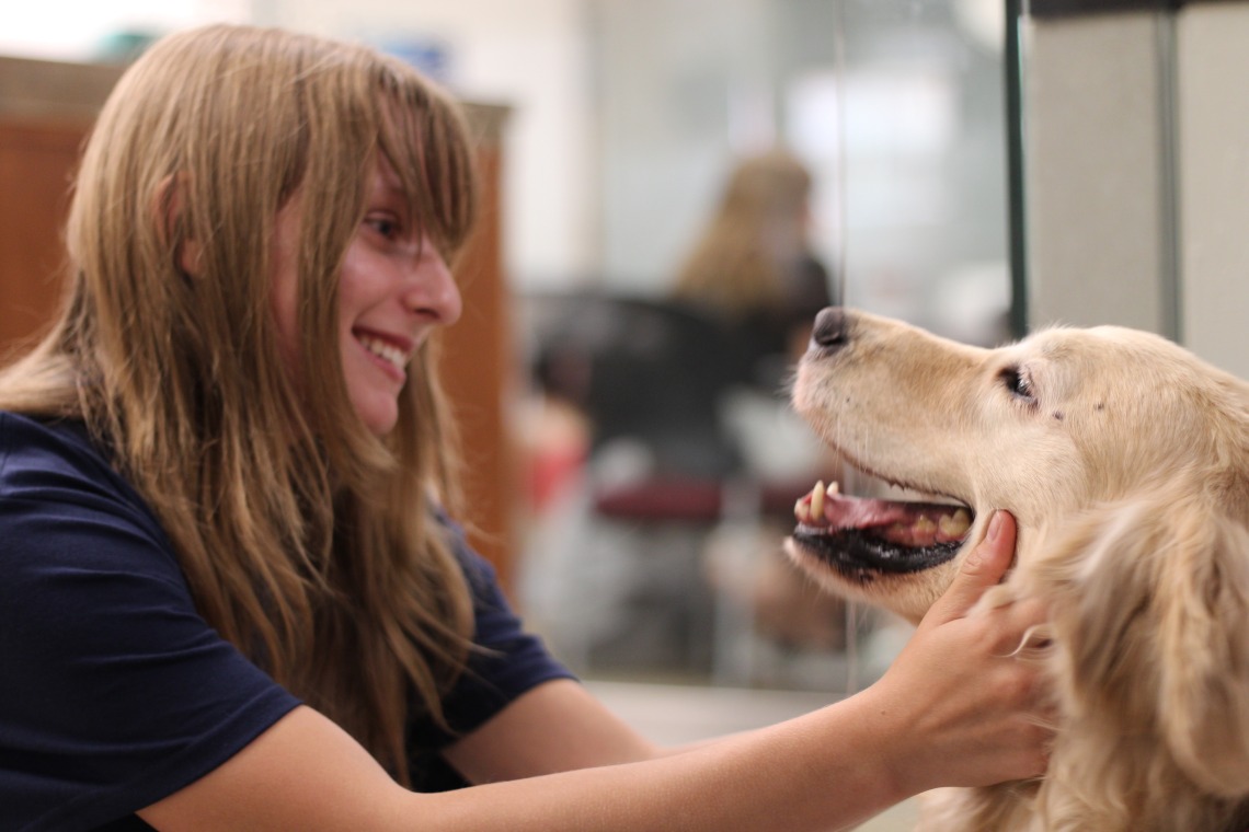 female student petting sally as she smiles